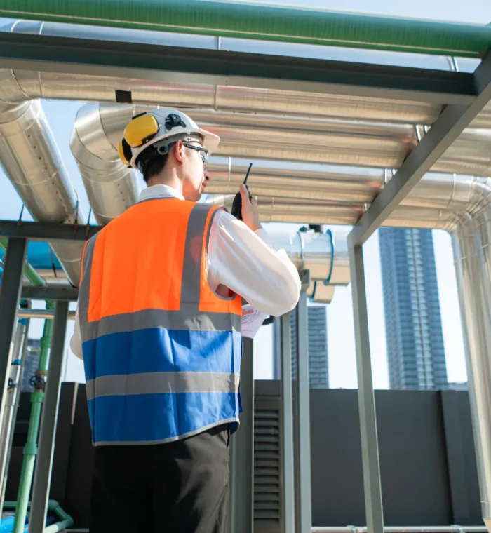 Back view of Engineers inspect the completed air conditioning and water systems to continue verifying their functionality.